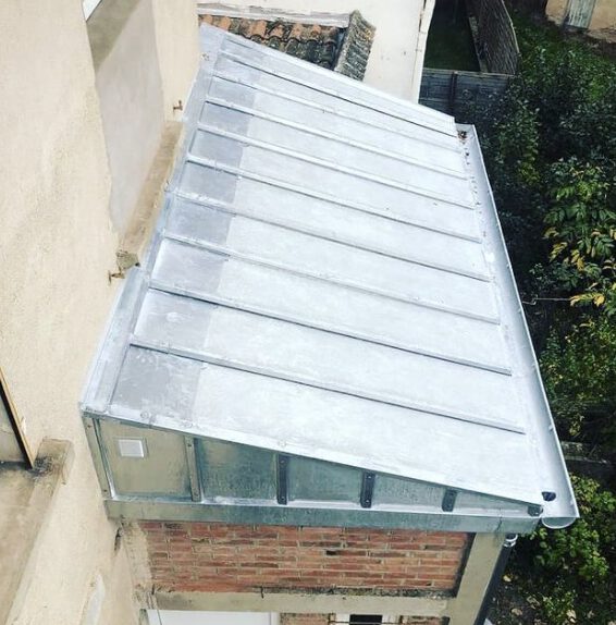 Toit en zinc et chéneaux sur une extension en briques apparentes